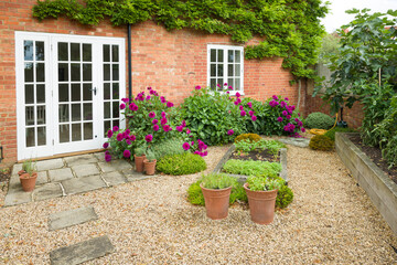 UK house and garden with hard landscaping patio and French doors