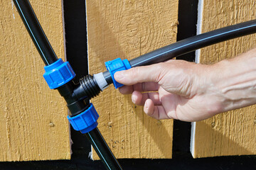 Plumber screws clamping nut onto tightening ring of compression tee fitting when installing an...