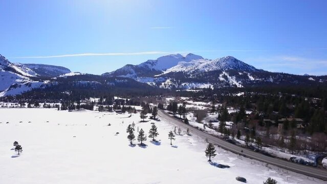 Mammoth Lakes Sierra Mountains California aerial cinematic drone flight winter spring sunny beautiful snow covered town June Lake Crowley Bishop skatepark upward movement