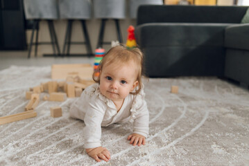 Naklejka premium Happy child happily playing on the floor at home, crawling and exploring the world