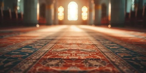 Fotobehang mosque interior illuminating by warm sunlight filtering through ornate windows on rug floor. Decorated carpet of a mosque with sunset light © MiniRiz