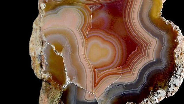 Agate - polished cross-section of geode, rotating slowly against a black background