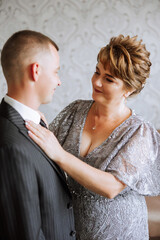 mother helps her adult son prepare for the wedding ceremony. An emotional and touching moment at a...