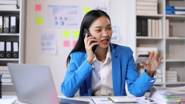 I dont want to hear excuses, just get it done. Serious Asian businesswoman talking on a mobile phone during a late night at work.