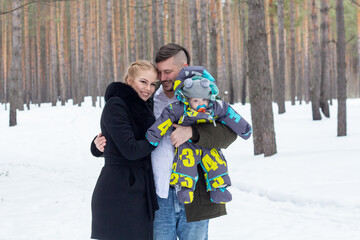 married couple with a baby in the winter forest