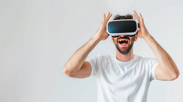 Young amuzed smiling man wearing VR glasses rasing hands