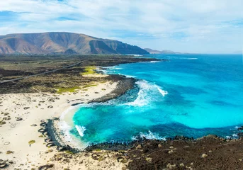 Fototapete Kanarische Inseln Aerial drone view of the rocky coastline in Lanzarote island and the volcanic mountain in the natural monument of Corona - Canary Islands, Spain