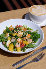 salad with haloumi cheese and a cup of coffee mix salad, asparagus, chicken, potatoes, cherry