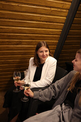 a picnic with wine in the evening on the terrace. romantic dinner with candles and wine. two women sit on the terrace of the house in a-frame style and drink wine