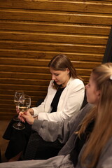 a picnic with wine in the evening on the terrace. romantic dinner with candles and wine. two women sit on the terrace of the house in a-frame style and drink wine