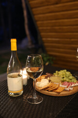 Fototapeta na wymiar a picnic with wine in the evening on the terrace. romantic dinner with candles and wine
