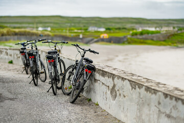 Electric bikes parked on Inishmore, the largest of the Aran Islands in Galway Bay. Renting a bicycle is one of the most popular way to get around Inis Mor, Ireland. - obrazy, fototapety, plakaty
