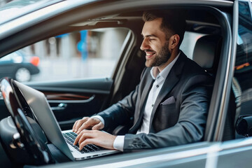beautiful businessman working on laptop computer while sitting in luxury car