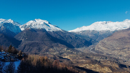 Aerial view of winter landscape with mountain peaks covered with snow in the italian Alps. Natural background.