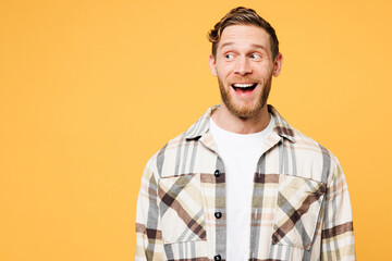 Young smiling satisfied happy surprised positive positive Caucasian man he wearing brown shirt casual clothes looking aside on area isolated on plain yellow orange color background. Lifestyle concept.