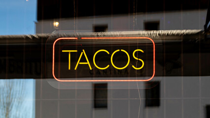 Neon Street sign that says Tacos, mexican restaurant