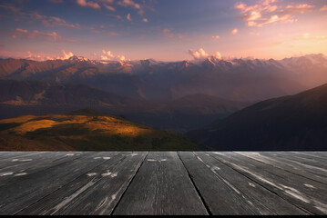 Beautiful sunrise over mountains and empty wooden table in nature outdoor. Natural template landscape