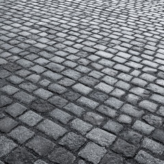 Old wet stone paved avenue street road