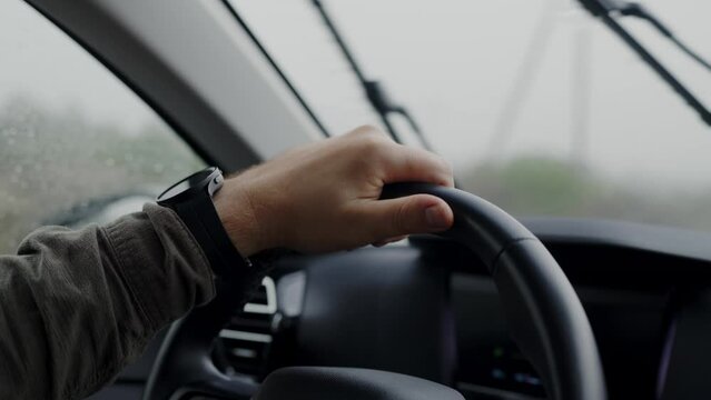 This video captures the scene of a person firmly gripping the steering wheel of a car, demonstrating control and readiness for driving.