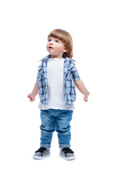 A surprised little boy looks up. A child with a fashionable haircut in jeans and a blue plaid shirt. Full height. Isolated on a white background. Vertical.