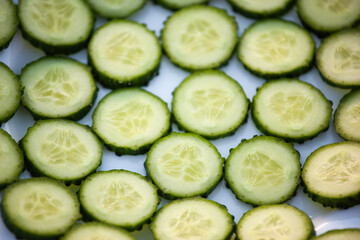 Background from green cucumber circles, top view. Fresh Cucumber sliced for publication, poster, calendar, post, screensaver, wallpaper, postcard, banner, cover, website. High quality photo