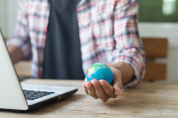 Man holding a globe while working online at home,work from home or concept.