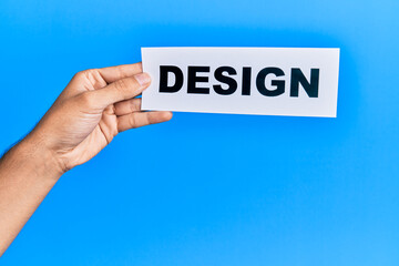 Hand of caucasian man holding paper with design word over isolated blue background