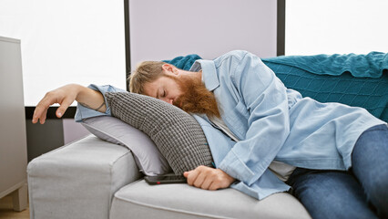 Exhausted young irish man with redhead beard finds comfort relaxing on cozy sofa, deeply sleeping...