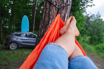 pov man laying down on hammock car with supboard on background
