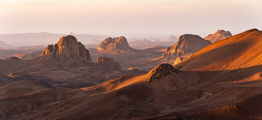 Hoggar landscape in the Sahara desert, Algeria. A view from Assekrem of the mountains and basalt organs that rise up in the morning light. - 739882531