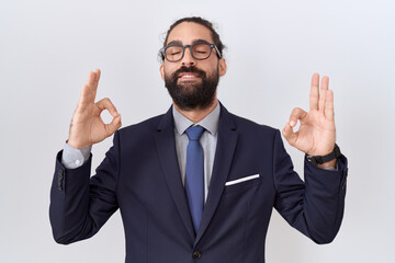 Hispanic man with beard wearing suit and tie relax and smiling with eyes closed doing meditation gesture with fingers. yoga concept.