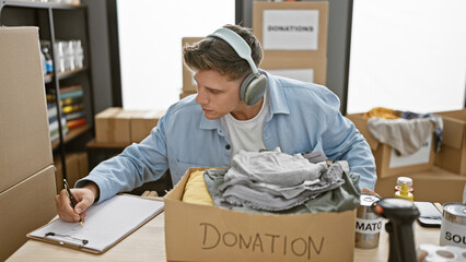 Attractive young caucasian man, a dedicated volunteer, immerses himself in music while meticulously...