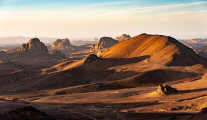 Hoggar landscape in the Sahara desert, Algeria. A view from Assekrem of the mountains and basalt organs that rise up in the morning light. - 739887109