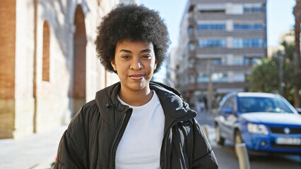 Portrait of a smiling african american woman with natural curly hair in urban setting