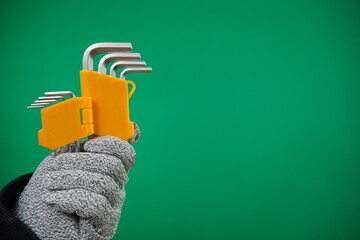 Set of hex keys in hand on green background