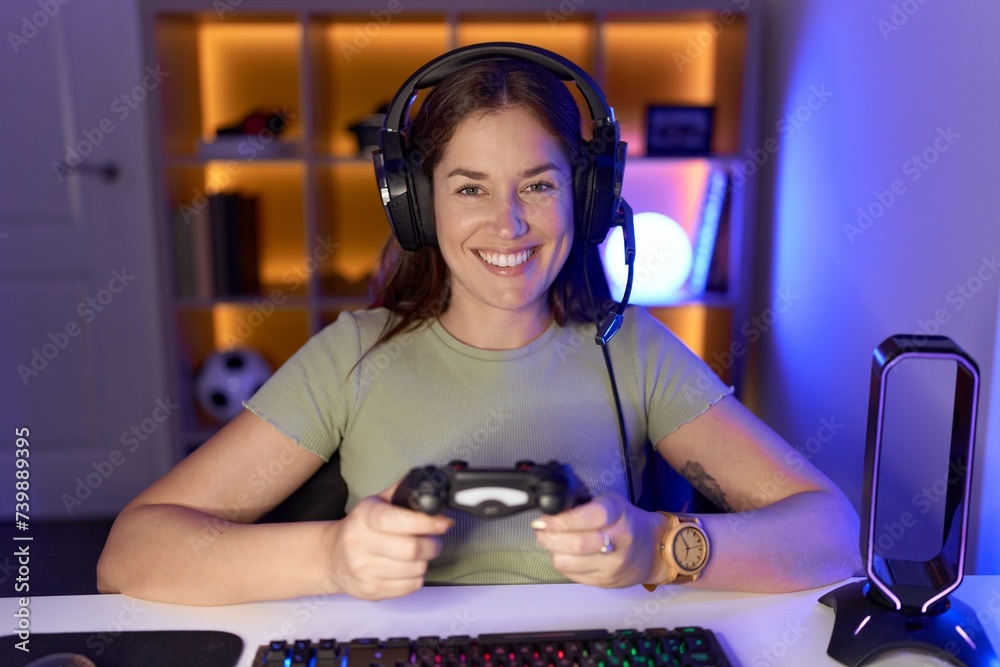 Poster Beautiful brunette woman playing video games wearing headphones with a happy and cool smile on face. lucky person.