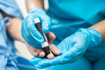 Doctor check diabetes from finger blood sugar level with finger lancet.