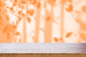 Blank wooden table on bright orange background