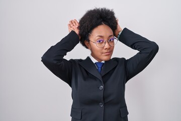 Beautiful african woman with curly hair wearing business jacket and glasses doing bunny ears...