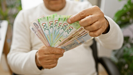 A mature hispanic man counts russian rubles in an indoor office setting, indicating finance and...