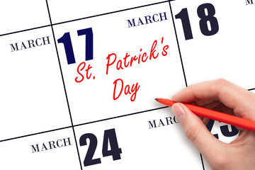 March 17. Hand writing text St. Patrick's Day on calendar date. Save the date.