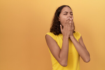 Young african american woman yawning over isolated yellow background