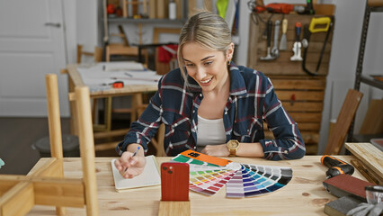 A young woman notes color options from a palette in a carpentry studio workshop.