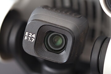 a close-up image of the lens and gimbal of a small grey camera drone that also shows the maximum aperture of the lens to be f 1.7