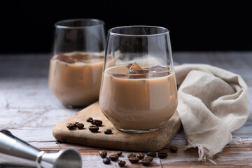 Traditional Irish cream coffee liqueur with ice on wooden table