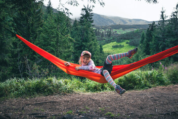 little cute girl at hammock in mountains