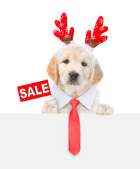 Cute Golden retriever puppy dressed like santa claus reindeer  Rudolf with necktie looks above...