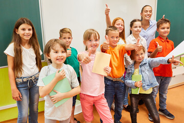 Happy students making thumbs up gesture in class