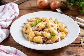 Cheese gnocchi with blue cream sauce and garlic, herbs on top