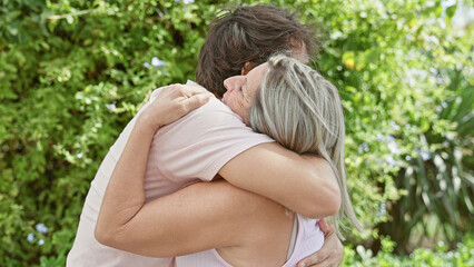 Confident mother and son share a joyful, sunny hug in the park, happily stage an expression of love, positivity, and family togetherness amidst nature